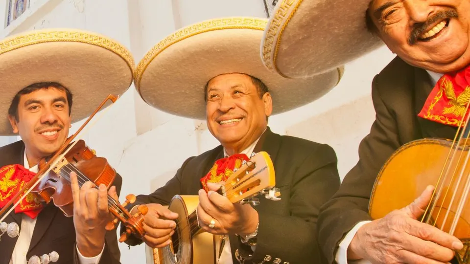 Gruppo di 3 mariachi con sombrero e strumenti musicali